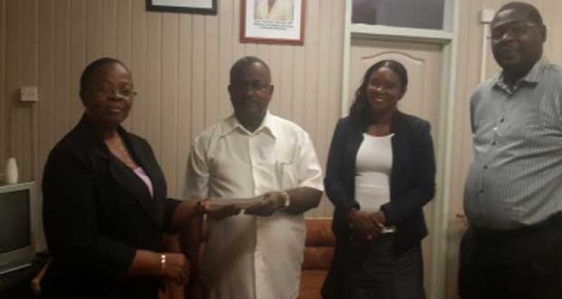 Administrator of Mrs. Wight estate, Mr. Edwin Verasammy presents the cheque to Permanent Secretary of the Ministry of Labour, Human Services and Social Security Mrs. Lorene Baird; in the presence of Ms. Jennifer Webster, Minister of Human Services & Social Security; and Mr. Whentworth Tanner, the Ministry’s Director of Social Services