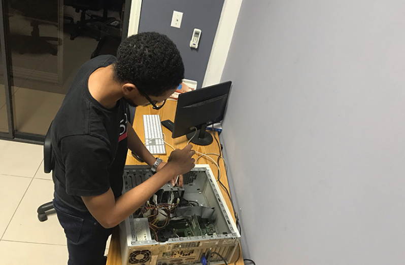 Nicolas Stephney fixing up an old computer which will be given to a student in need