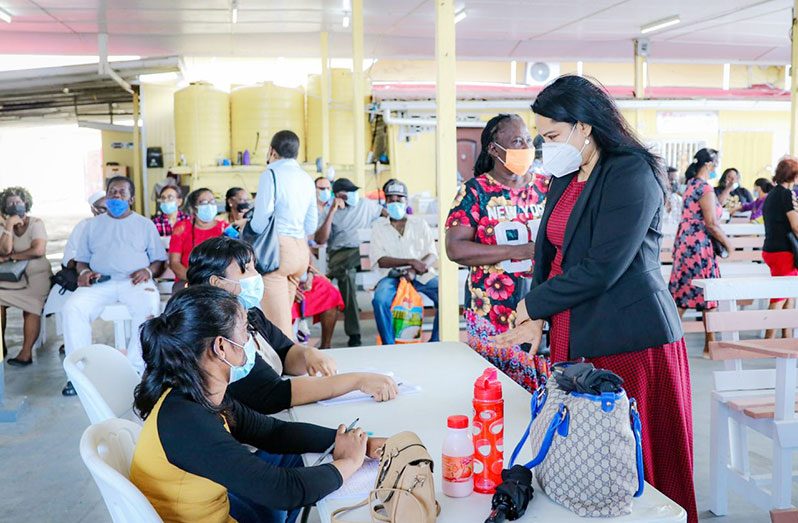 Human Services and Social Security Minister, Dr. Vindhya Persaud interacts with residents and officers during the recent distribution exercise.