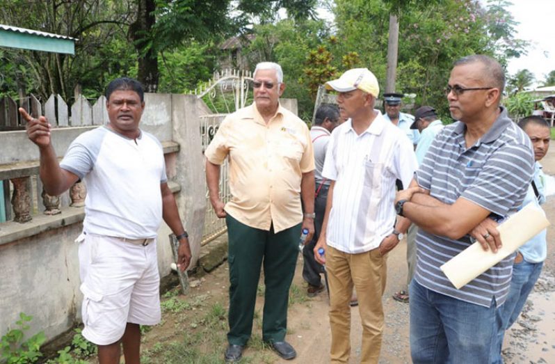 Ministers Holder and Bulkan and Nizam Hassan listen as a resident make a point (DPI photo)
