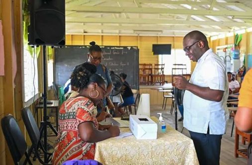 Minister within the Office of the Prime Minister with responsibility for Public Affairs, Kwame McCoy, engages teachers and parents at the cash grant distribution at the Mocha/Arcadia Primary School