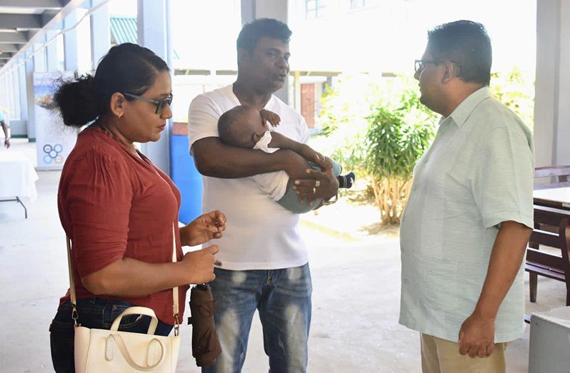 Dr Ashni Singh interacting with a family on Saturday at the Muneshwer’s Job Fair