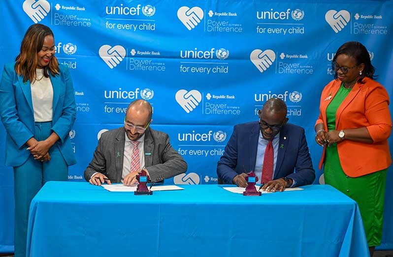 The joint agreement being inked by UNICEF’s Representative, Xavier Cardova and Republic Bank’s Director, Dr Toussant Boyce (Elton John photos)