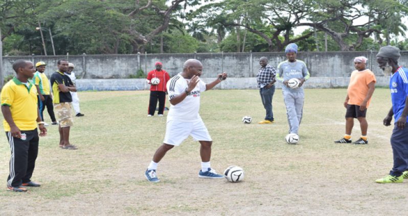 Ivor `Brazilian’ Jones (centre) executes a flat pass yesterday when he held a football coaches seminar at the GFC ground, Bourda. Twenty-five coaches from mainly Georgetown benefited from the programme (Photo by Cullen Bess-Nelson)
.