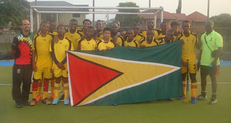 Guyana’s National Junior Men's Team pose with coaches Dwayne Alleyne and Robert Fernandes at the end of their match against Trinidad.