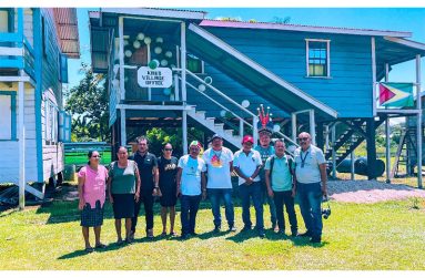 Toshao Romario Hastings poses with locals in front of the Kako Village Council office