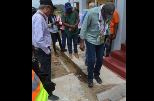 Minister of Public Infrastructure, David Patterson, easily breaking the ground with his boots as Minister of Education, Dr. Rupert Roopnaraine, looks on