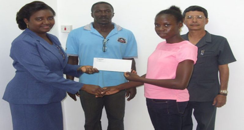 Human Resources manager Joy Lewis hands over sponsorship to Kenisha Phillips while director Colin Ming and coach Linden Phillips look on.