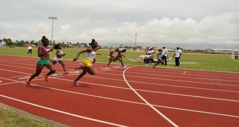 Kenisha Phillips (extreme right) breezes past the finish line to go on record as the first athlete to officially win a track event on Guyana’s first synthetic track at Leonora yesterday. (Delano Williams photos)