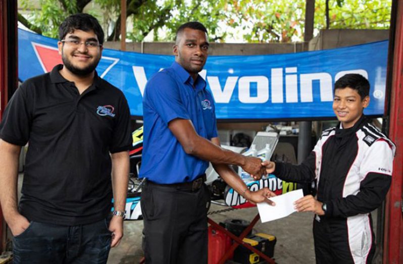 Nathan Rahaman is all smiles as he collects sponsorship from Sankar’s Auto Works representative Keon Joseph in the presence of Navin Sankar.