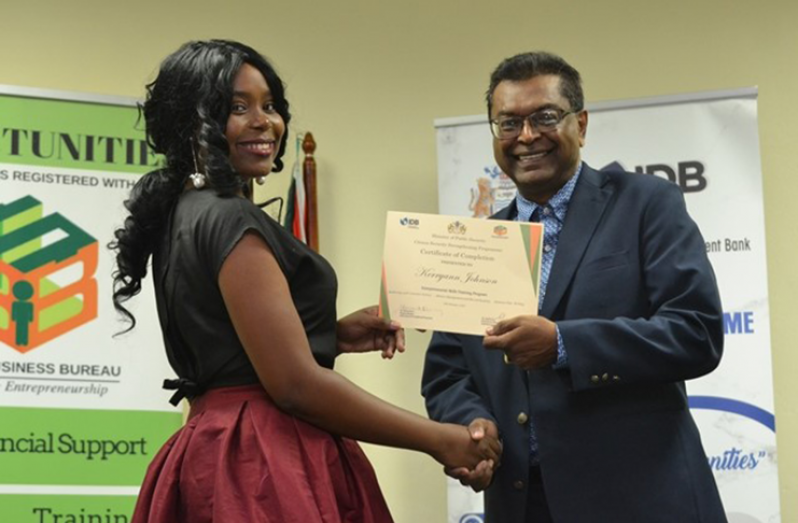 Kerryann Johnson receiving her certificate from Minister of Public Security, Khemraj Ramjattan