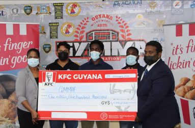 Beharry Restaurant Holdings’ Marketing Officer, Pamela Manasseh, presents her company’s cheque to GYMMA Sherwin Sandy. Also present are several fighters of the GYMMA’s National team