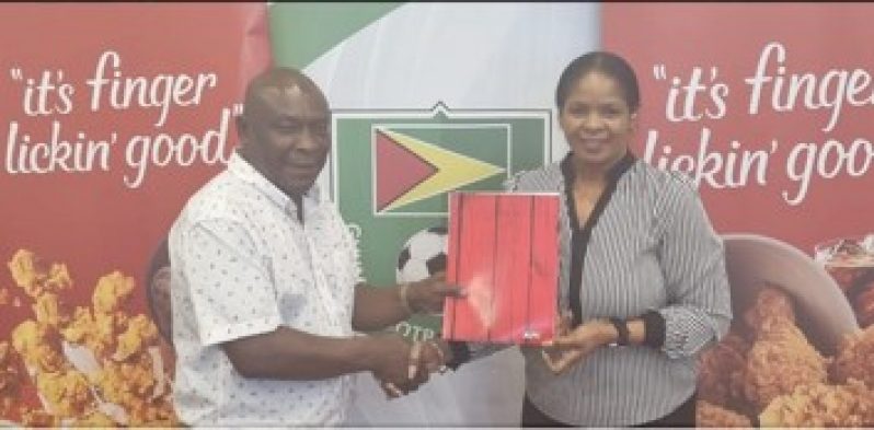 Troy Peters of the GFF receives the cheque from KFC's Pamella Manasseh