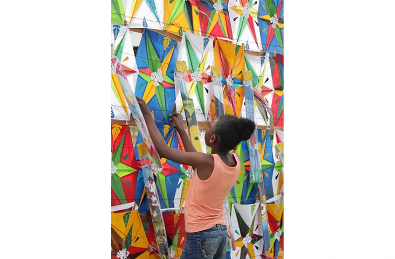 A young girl checks out one of the hundreds of kites on display on Camp Street
