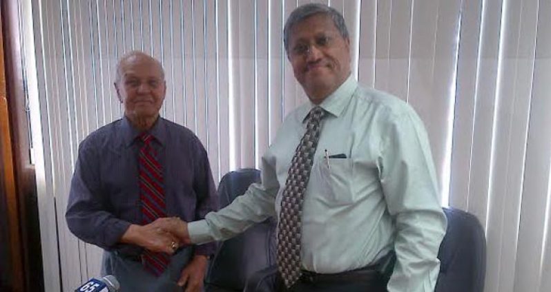 Dr. Yesu Persaud, left, hands over the DDL reins to Mr. Komal Samaroo