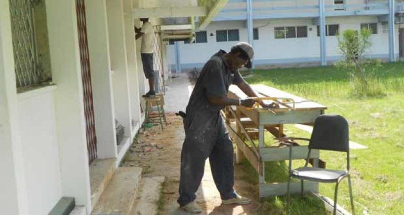 Men working on the laboratory situated at the front of the Faculty of Health Sciences at the University of Guyana. (Photo courtesy splash.gy)
