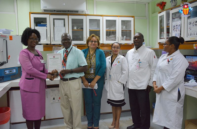 Head of the Conformity Assessment Department of the GNBS, Rodlyn Semple presents the certificate to the hospital’s Chief Executive Officer, Mr. Enoch Gaskin