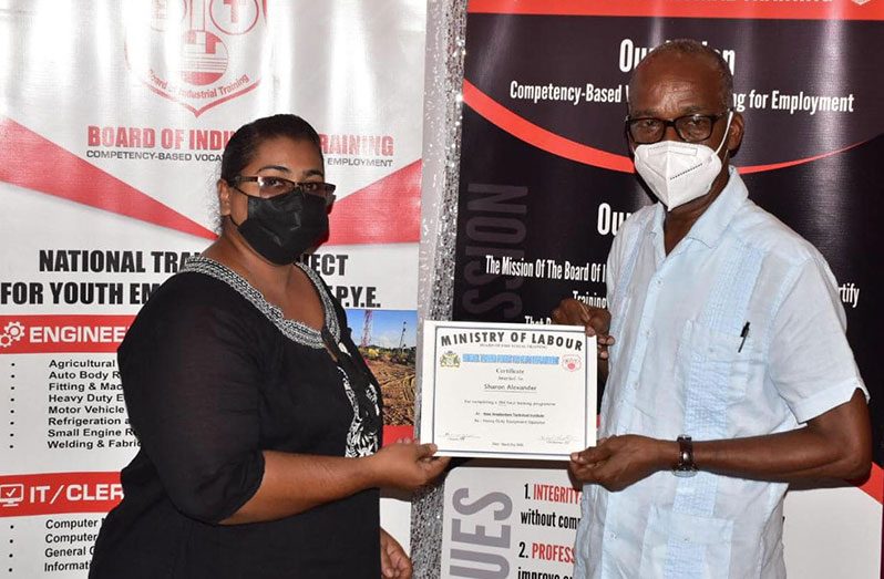 Labour Minister, Joseph Hamilton (right) handing over a certificate to one of the graduates