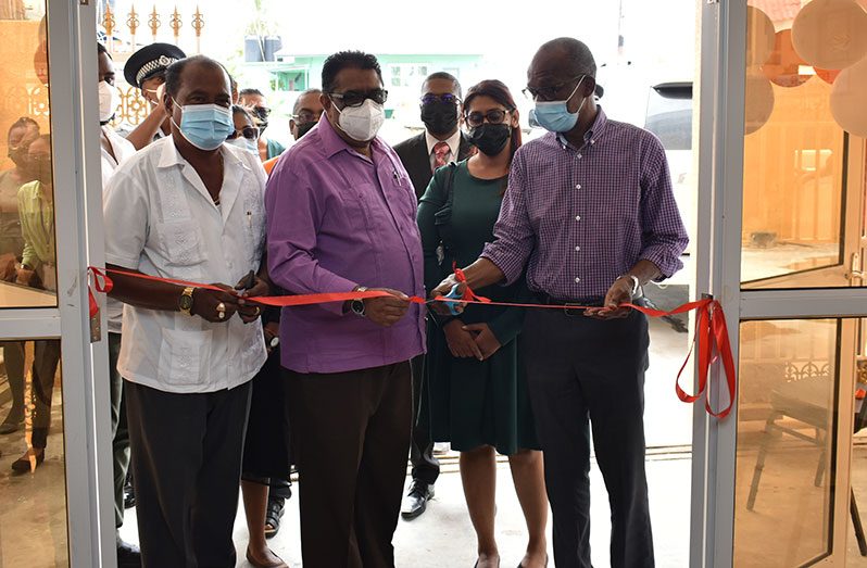 Minister of Labour, Joseph Hamilton (right) is assisted by Regional Chairman, David Armogan, to cut the ceremonial ribbon to officially open the ministry’s labour office at Corriverton (Elvin Croker photo)