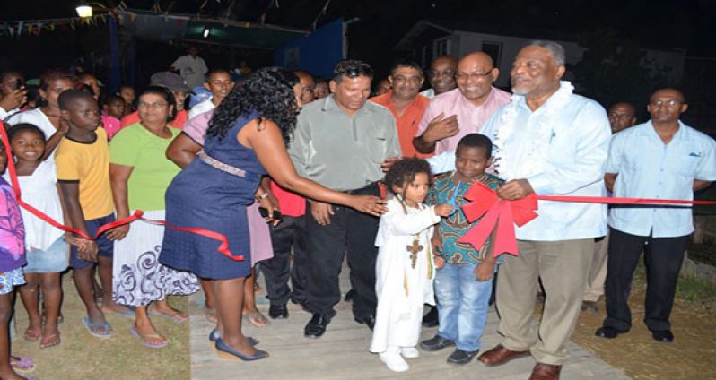 A boy cuts the ribbon to commission Angoy’s Avenue’s electricity supply
