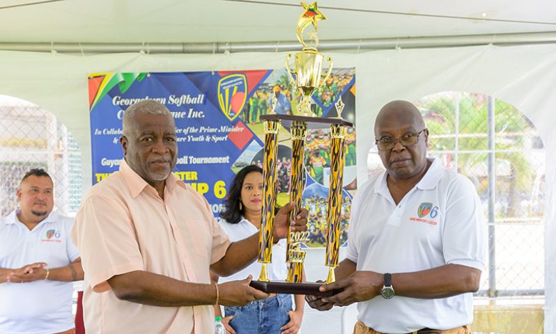 Flashback: Prime Minister Mark Phillips and GSCL president Ian John pose with one of the trophies that will be up for grabs in the tournament