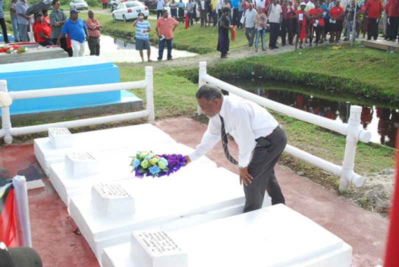 Prime Minister Samuel Hinds lays a wreath on the grave of one of the five Enmore Martyrs