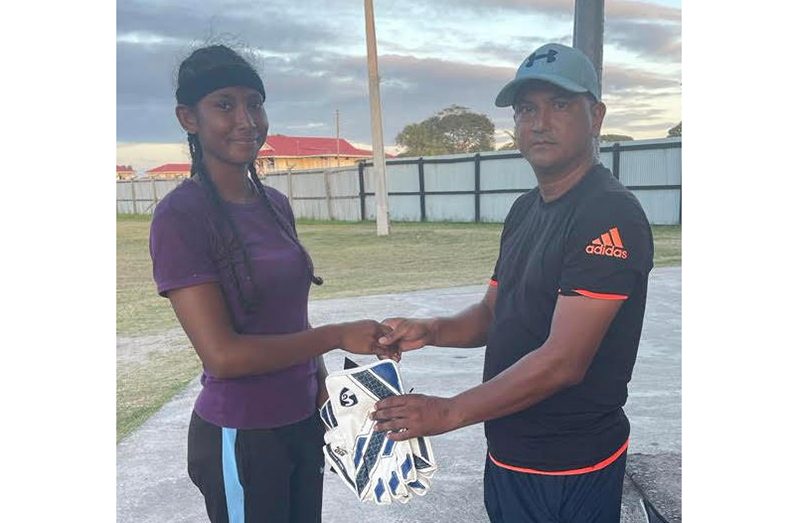 Dinelle Lindee receives wicket-keeping gloves from Balram Samaroo
