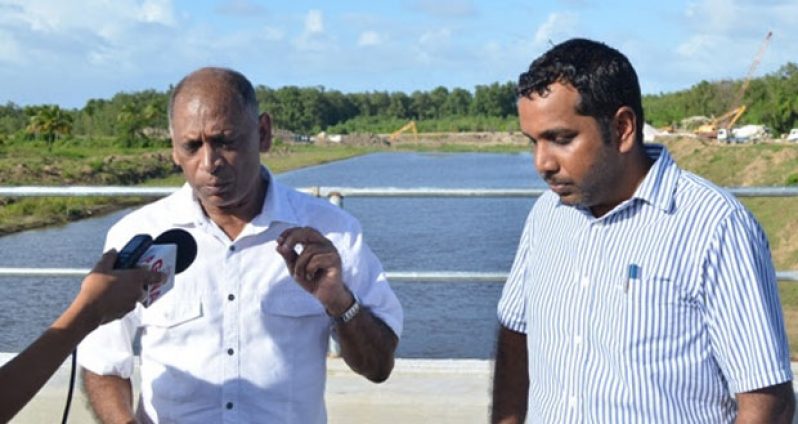 Minister of Agriculture Dr. Leslie Ramsammy in the company of the Chief Executive Officer, National Drainage and Irrigation Authority, Lionel Wordsworth, speaks to GINA  atop  the Hope Bridge