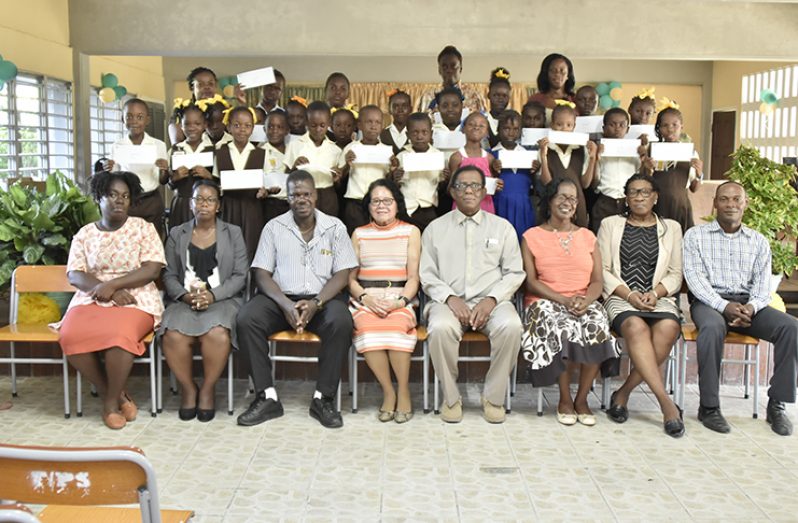 First Lady Mrs. Sandra Granger( 4th left) poses with the successful students, their teachers and other officials (Ministry of the Presidency photo)