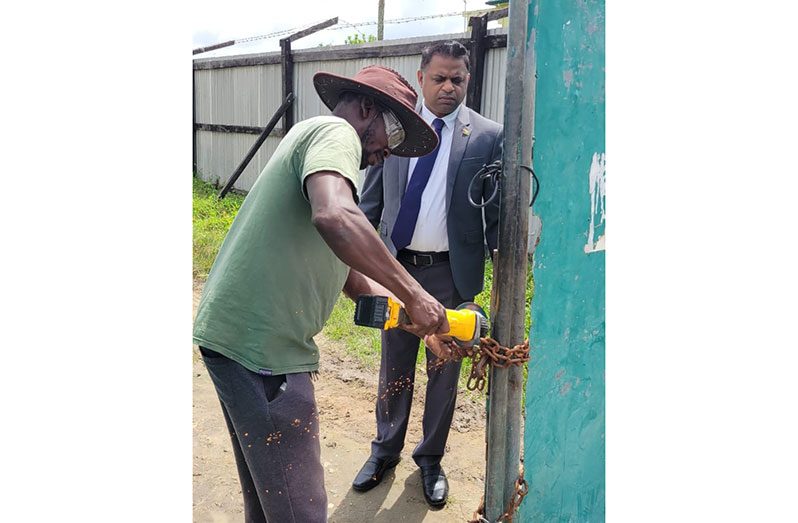 Minister within the Ministry of Public Works, Deodat Indar ensuring the locks were removed for re-commencement of works at the community ground