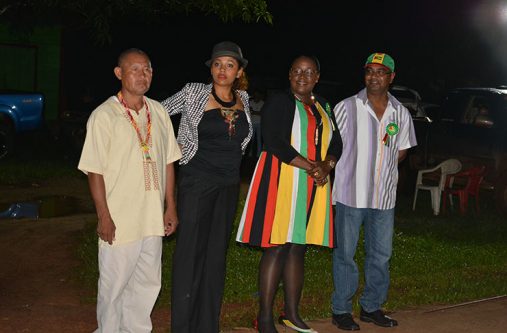 Minister Simona Broomes (second right) and regional officials await the hoisting of the Golden Arrowhead