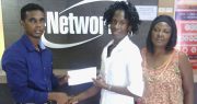 Former national track athlete and double CARIFTA Games gold medallist Lorrie Ann Adams (centre) accepts the sponsorship cheque from E-Networks’ accountant Shivanan Singh while race committee member Avril Black looks on.