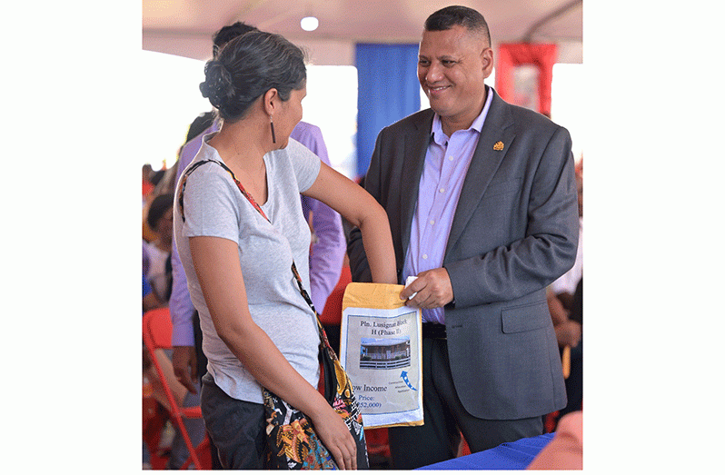 A citizen selects a house lot from Minister Colin Croal at the ongoing Building Expo (Ministry of Housing and Water photo)