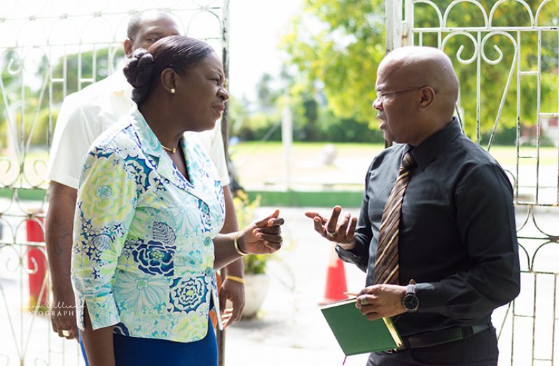 Minister of Education Nicolette Henry engages Paul Burnette, the school’s Director (ag) of the Secondary Department