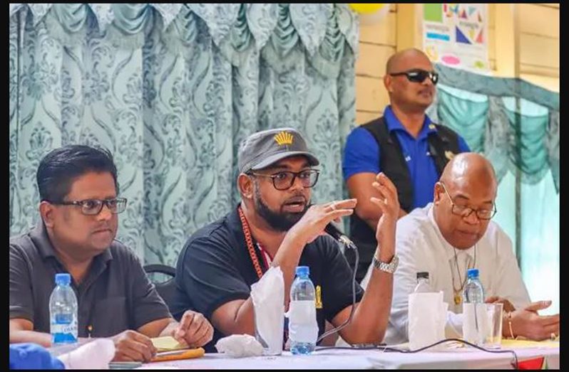 President Dr Irfaan Ali addressing the residents of Malali. Also pictured are Senior Minister in the Office of the President with Responsibility for Finance, Dr. Ashni Singh (left) and Minister of Public Works, Bishop Juan Edghill (right)