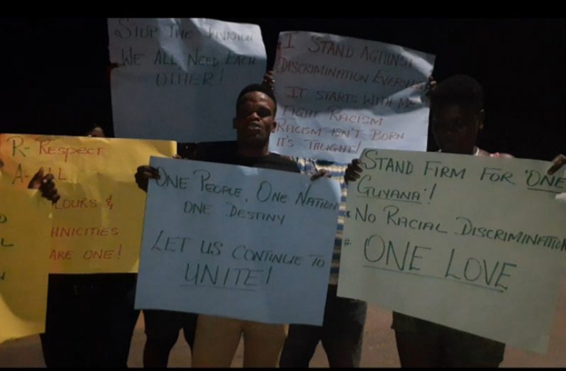 Michael Spencer, centre, surrounded by fellow marchers bearing placards during Sunday’s march against racism