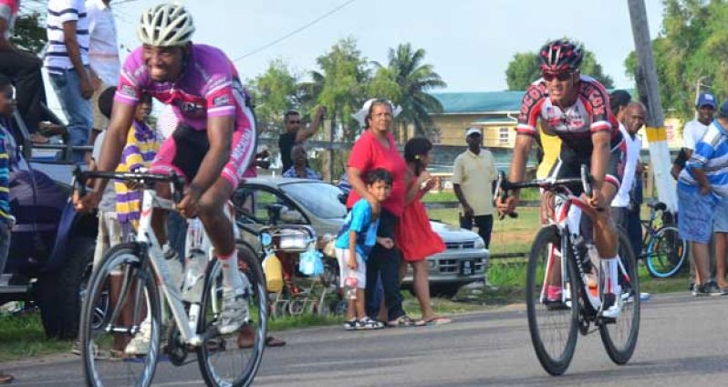 Marlon `Fishy’ Williams (left) crosses the finish line to win the second stage ahead of race leader, Barbados’ Darren Matthews, yesterday on Carifesta Avenue (Adrian Narine photo).