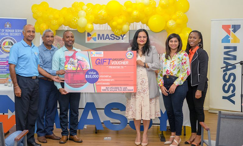 Representatives of Massy Distribution hand over the first women’s grocery voucher to Minister of Human Services and Social Security, Dr. Vindyha Persaud (Delano Williams photo)