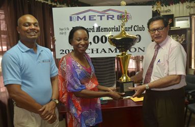In this Cullen Bess-Nelson photo, Metro’s CEO Avia Maria Lindie (second left) presents Justice Cecil Kennard with the trophy for the winning horse of the feature event, while at extreme left is Metro’s manager Bernard Ramsaroop.