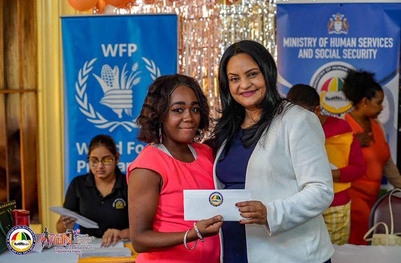 Minister of Human Services and Social Security, Dr. Vindhya Persaud (right), with one of the recipients