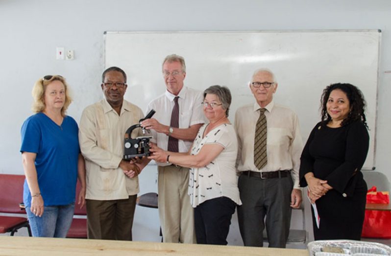 One of the microscopes being handed over to Professor Ivelaw Griffith