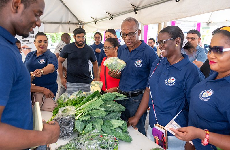 Laboour Minister Joseph Hamilton and other officials at one of the Market Day booths (Delano Williams photos)