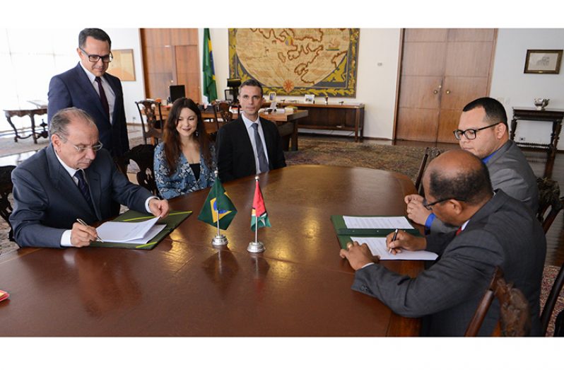 Guyana’s Ambassador to Brazil, His Excellency George Talbot and Foreign Minister of Brazil, His Excellency Aloysio Nunes Ferreira signing the agreement in the presence of their aides
