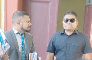 Defence attorney Siand Dhurjon speaks to his U.S.-sanctioned client Azruddin Mohamed, as the pair exits the courtroom on Monday