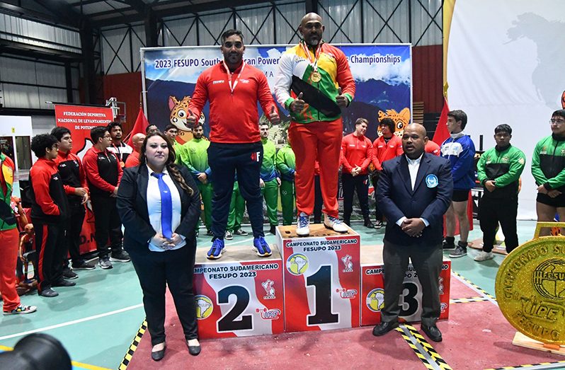 Mohamed Wazim shares the podium with second-placed Chilean, Bernado Ibenez. Guyanese Level 11 IPF Referee, Andrew Austin is at right