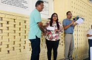 Ms Indrawattie Natram hands over a cheque worth $1 million to the Chairman of the Board of Governors of the Anna Regina Secondary School, Mr Bolaram Mohan in the presence of the headmaster, Lalljeet Rooplall