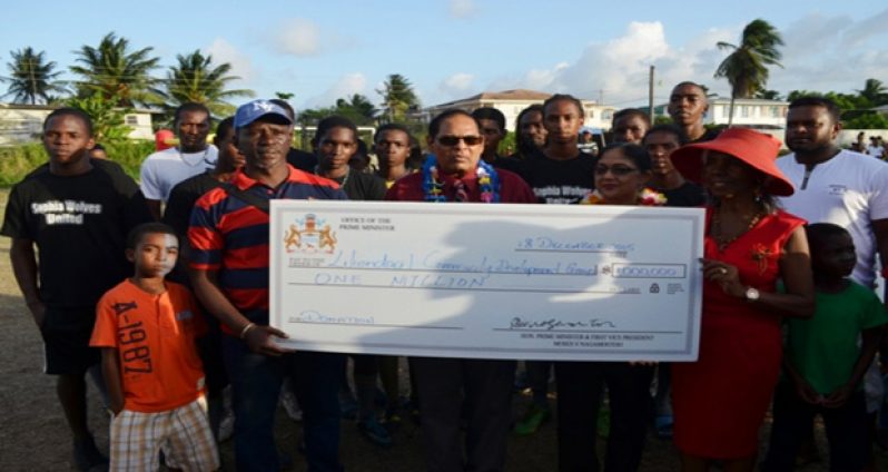Prime Minister Moses Nagamootoo and wife Sita Nagamootoo hand over the cheque to founder of the Liliendaal Community Development Group, Beryl Haynes, in the presence of the community members