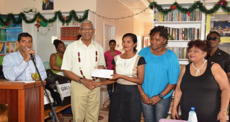 President David Granger presents a $2M cheque to Administrator of the Good Hope-Lusignan Learning Centre Annette Roopchand, while Ministers Annette Ferguson and Amna Ally look on 