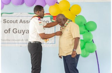 Chief Commissioner Yonnick David presents Prime Minister of Guyana, Brigadier (Ret'd) Mark Phillips with an honorary scout badge