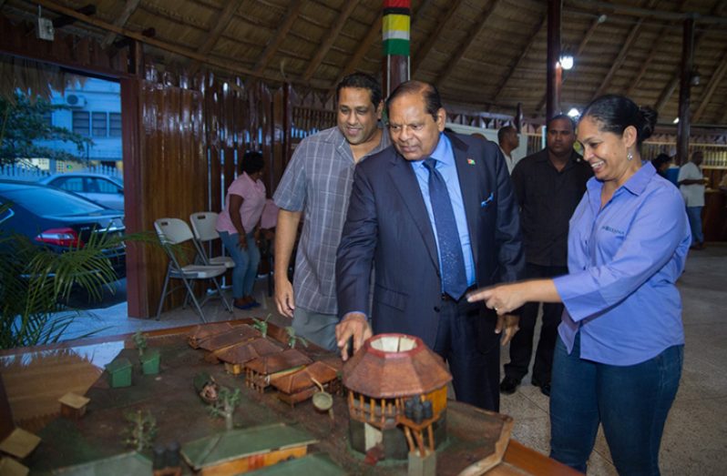 In this DPI photo Prime Minister Moses Nagamootoo and Dr. Thomas check out one of the exhibits on display in the presence of other staff members